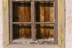 Closeup view photography of old wooden window of abandoned house boarded up.