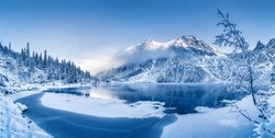 Winter panoramic landscape with scenic frozen mountain lake and clear blue sky. Alps, Switzerland.