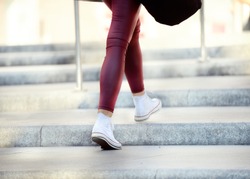 Young adult woman walking up the stairs