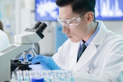 close up of asian male scientist team use microscope in the laboratory