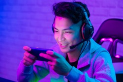 Young Asian Handsome vlogger having live stream and play online Video Game