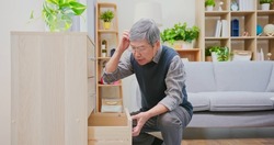 memory error concept - asian older man wearing reading glasses is rummaged in all drawers while looking for something that he forgot it