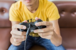 A young man holding game controller playing video games