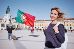 Traveling by Portugal. Happy young woman with rucksack walking by square of Commerce in Lisbon.