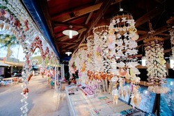 A souvenir store decorated with natural, sea shells hanging  at the front on a tourists street. Phuket, Thailand.