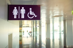 Toilets icon. Public restroom signs with a disabled access symbol. Interior of airport terminal.