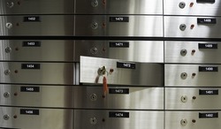 Safe deposit boxes inside bank vault. Open deposit box with key