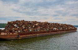 Transportation industry. Ship barge transports scrap metal and sand with gravel