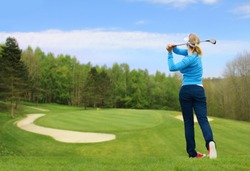 Caucasian female golfer hit a golf ball by golf-club driver