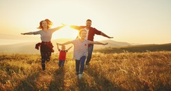Happy family: mother, father, children son and  daughter on nature  on sunset