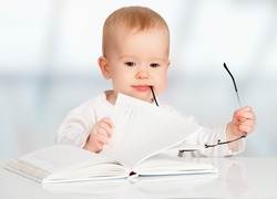 funny baby with glasses reading a book