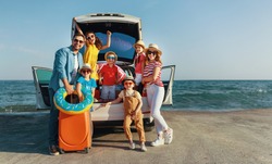 happy large family mother father and children in summer auto journey travel by car on beach