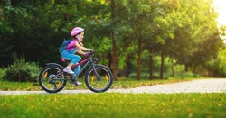happy cheerful child girl riding a bike in Park in the nature