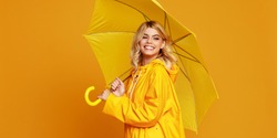 young happy emotional cheerful girl laughing  with umbrella   on colored yellow background