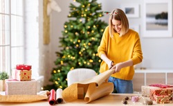 happy young woman gets ready for christmas and wrapping a gift