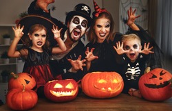 happy family mother father and children in costumes and makeup on a celebration of Halloween
