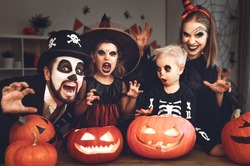 happy family mother father and children in costumes and makeup on a celebration of Halloween