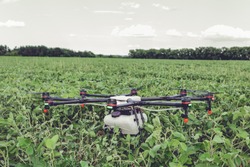 Professional agriculture drone stands on the ground green field. Octocopter flight preparation