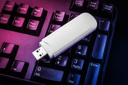 USB flash drive lying on black keyboard. Virtual memory storage with USB output