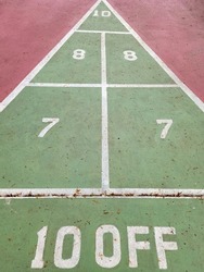 Outdoor shuffleboard game with numbers on concrete