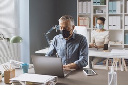 Coronavirus prevention and social distancing in the office: business people keeping safety distance and wearing a face mask, coronavirus prevention concept