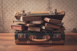 Old suitcase full of vintage books and novels, reading and travel concept