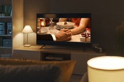 Romantic comedy movie streaming on TV and living room interior