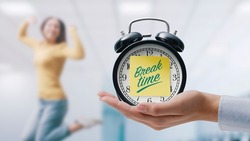 Hand showing a vintage clock with sticky note and happy woman jumping and celebrating, it's break time