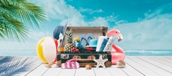 Vintage suitcase with colorful summer accessories at the tropical beach on the deck, summer vacations concept, copy space