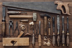 Collection of vintage carpentry tools on an old workbench: woodworking, craftsmanship and handwork concept, flat lay
