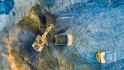 Quarry mining, work of the excavator and dump trucks, photo from the air