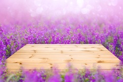 Empty wooden table top with purple or violet flower fields