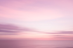 Abstract pink sunset sky and ocean nature background with blurred panning motion.