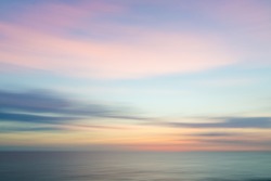 Abstract sunset sky and ocean nature background with blurred panning motion.