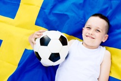 Sweden national football team. Child boy with football ball and Swedish flag
