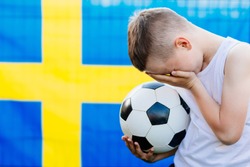 Disappointed Sweden national football team supporter. Child boy with Sweden flag. Football fan