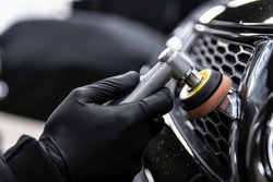 Car detailing technician polishing chrome shine decor on car