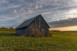 Old weathered abandoned wooden barn in a farm field at sunrise. Hdr images.  Hdr. Barn. Shed. Abandoned. Old fashioned.  Farm. Rustic. Wooden. Ancient. Dramatic sky. Rural. Countryside. High dynamic.