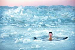 Winter swimming. Man in an ice-hole