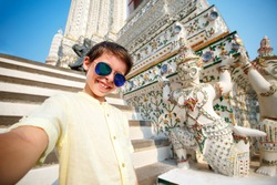 Cute little boy taking a selfie at temple Wat Arun, Thailand, Asia