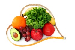 Fruits and vegetables surrounded by a heart shaped measuring tape on white background