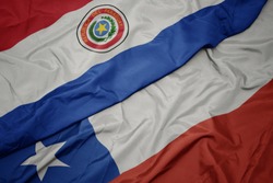waving colorful flag of chile and national flag of paraguay. macro