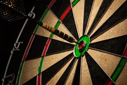 Success hitting target aim goal achievement concept background - dart in bull's eye close up