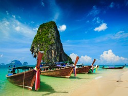 Long tail boat on tropical beach with limestone rock, Krabi, Thailand