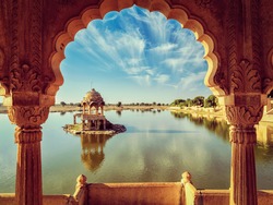 Vintage retro effect filtered hipster style image of Indian landmark Gadi Sagar - artificial lake view through arch. Jaisalmer, Rajasthan, India