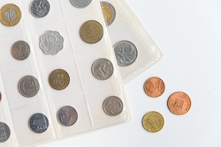 Flat lay of the numismatic album sheets and coins. Collection of different coins on the white with copy space