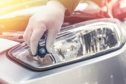 the mechanic replaces the halogen bulbs in the headlights in the car. auto technolgy