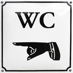 Old style sign with human hand pointing the direction to the toilet.