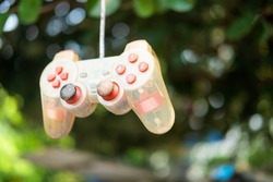 Video game controller, old and unusable on a bokeh background