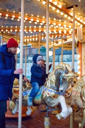 son and dad ride a carousel in winter in Moscow 2020 for Christmas